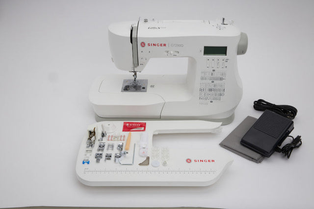 Singer C7290Q sewing machine with extension table, displayed alongside included presser feet and accessories, featured in a comparison with the Brother CS600I.